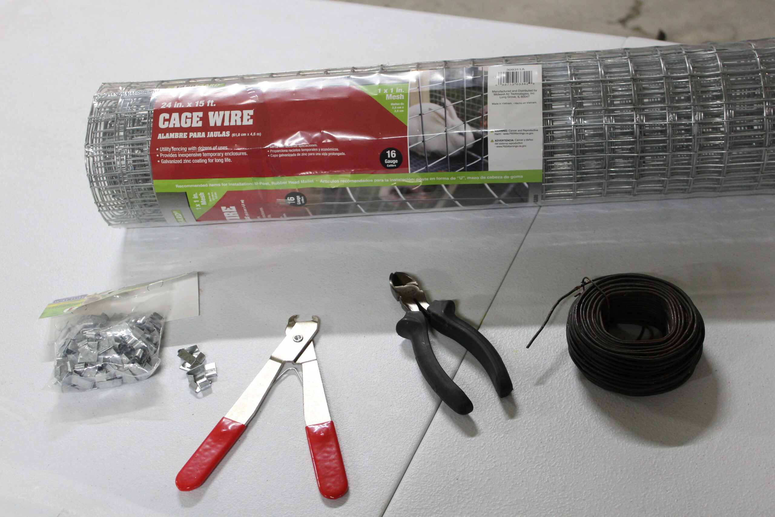 Materials for building DIY muskrat sets, including cage wire, J-clips, pliers, side cutters, and Number 9 wire